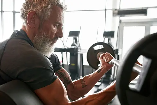 Man over 50 following a workout routine in the gym